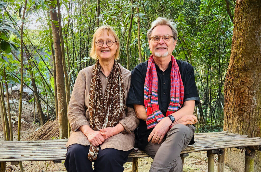 PO och Elisabeth på en bänk med grönska i bakgrunden