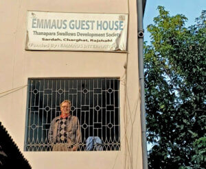 PO syns i fönster under en skylt där det står EMMAUS GUEST HOUSE - Thanapara Swallows Development Society